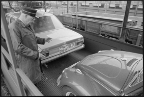 Bahnangestellter beim Einweisen von Autos auf Autozug