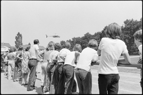 Kinder und Erwachsene beobachten den Start eines Helikopters