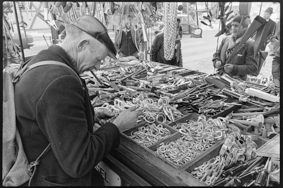 Marktbesucher bei Marktstand mit Metallwaren