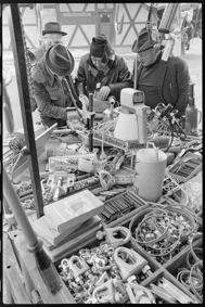 Marktbesucher bei Marktstand mit Metallwaren