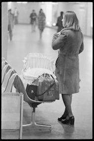 Frau mit Babytasche und Gepäck in der Bahnhofunterführung