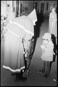 Samichlaus mit Einkaufswagen, Kind sagt vermutlich ein Versli auf