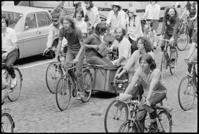Demonstrierende mit Fahrrädern und Transparenten fahren durch die Strassen der Innenstadt, in einem Velo-Anhänger zwei Musizierende