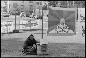 Demonstrierender mit Tibet-Fahne und Transparenten