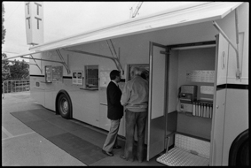 Mobiles Postbüro mit Postschaltern und Telefonkabine