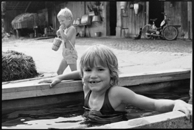 Kind nimmt ein Bad im Brunnen bei einem Bauernhof