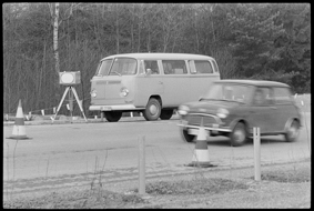 VW-Bus neben Radarkasten, vorbeifahrendes Auto