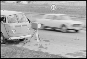 VW-Bus neben Radarkasten, vorbeifahrendes Auto