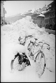 Eingeschneite Zweiräder neben Schneehaufen