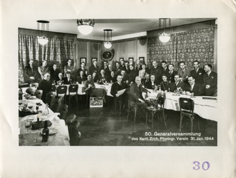 Mitglieder des Zürcher Photographen Vereins posieren für ein Gruppenfoto im Säli einer Gastwirtschaft, anlässlich der 50. Generalversammlung