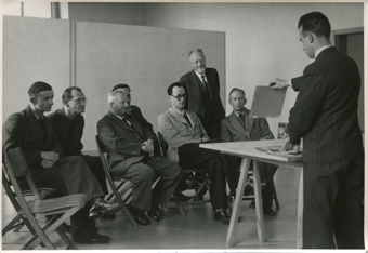 Mitglieder des Zürcher Photographen Vereins unter anderem Pfeifer Otto (l.), Albert Tschopp (2. v. l.), Prof. Dr. Ernst Rüst (3. v. r.) und Jacques Weiss (4. v. r.; 1904-1989), werden Fotos gezeigt