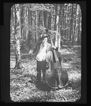 Ein Mann, Kontrabass spielend in einem Wald