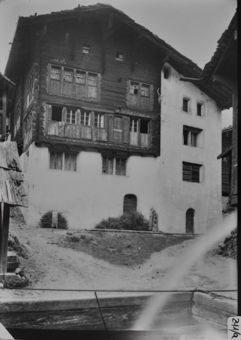 Giebeseite fünfstöckiges Wohngebäude, Erdgeschoss, 1. OG und rechte Gebäudehälfte gemauert, restlicher Teil gezimmert, von Blockkonsolen getragenes Schleppdach, Sprossenfenster und Butzenscheiben, Fensterrahmen mit Ausschnittornamentik, Haus Anton Breer