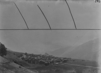Ortsaufnahme, Dorf auf Plateau mit Holzgebäuden und gemauerter Kirche im Zentrum