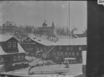 Winterliche Ortsaufnahme mehrernen Holzgebäunde mit schneebedeckten Pultdächern