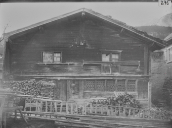 Giebelseite zweistöckiges Holzhaus mit Satteldach Fensterfront im Erdgeschoss mit Butzenscheiben, davor aufgestapeltes Brennholz, Lattenzaun und Holzstangen, Geburtshaus Huldrych Zwingli 