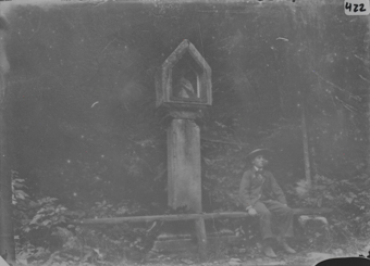 Sitzendes Kind vor Heiligenstatue