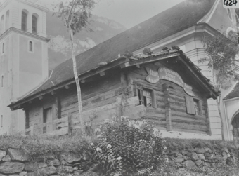 Holzgebäude vor einer Kirche