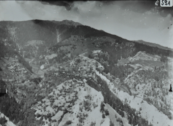 Ansicht des Bergdorfes aus der Ferne, Dorf auf Hügel erbaut, im Hintergrund weiteres Dorf und Hügelkette