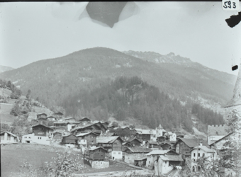 Ansicht des Dorfes, Dorf am leichen Hang gelegen, Häuser teilweise aus Holz und Steinen, hinter dem Dorf Hügel mit Wald