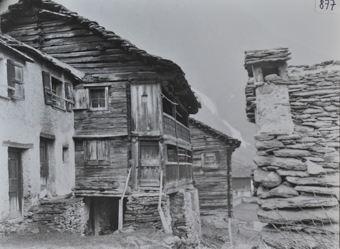 Zweistöckiges Wohnhaus aus Holz, Haus steht auf Steinpfeilern aufgrund des Geälles, Satteldach, gemauerter zweistöckiger Anbau vor dem Wohnhaus, Steintreppe führt zum Eingang
