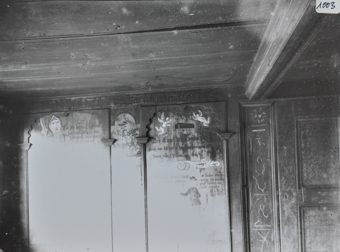 Innenaufnahme eines Zimmers, die Wände sind verziert mit Bildern und Inschriften, Decke aus Holz