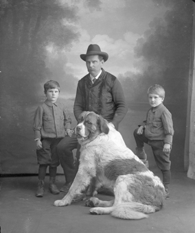 Mann mit zwei Knaben und Hund