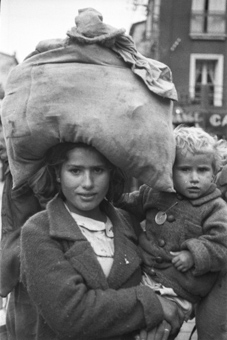 Mutter mit einem Sack auf dem Kopf und ihrem Kind im Arm