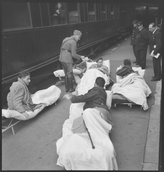 Vewundete der Internationalen Brigade sind mit dem Zug aus Barcelona eingetroffen und warten auf den Weitertransport