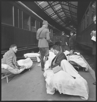 Vewundete der Internationalen Brigade sind mit dem Zug aus Barcelona eingetroffen und warten auf den Weitertransport
