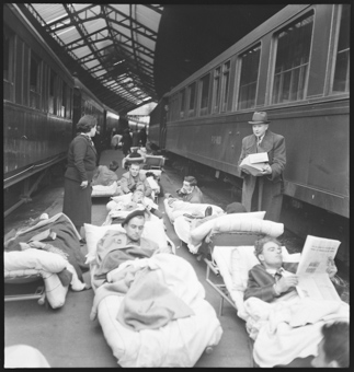 Vewundete der Internationalen Brigade sind mit dem Zug aus Barcelona eingetroffen und warten auf den Weitertransport