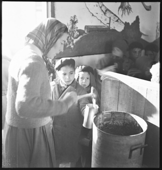 Elsie Ruth verteilt eine Mahlzeit in der Schweizer Baracke