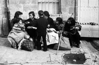 Spanische Flüchtlinge sitzen vor einem Gebäude