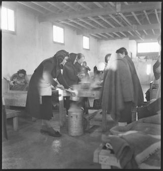 Frauen bereiten Essen vor in einer Kinderbaracke