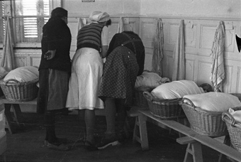 Maria García (Mitte) mit zwei Müttern vor den Säuglingen in den Körben