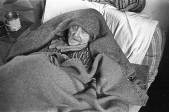 Ältere Frau, liegend im Bett