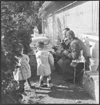 Eine Frau mit einem Mann, sitzend vor dem Kinderheim