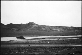 Persien, Persepolis: Landschaft (Lokalisierung unsicher); Landschaft mit Fluss, darin ein Automobil, im Hintergrund Berge. Aufgenommen ev. auf der Fahrt nach Persepolis