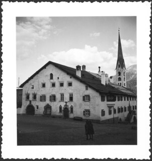 Schweiz, Zuoz: Häuser; 2stöckiges Haus mit Kirchturm im Hintergrund; Zuoz