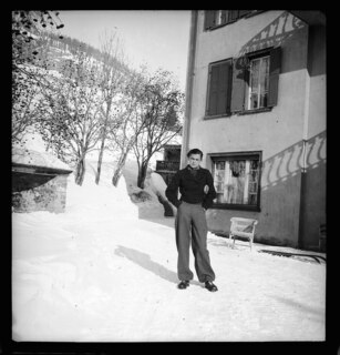 Schweiz, Engadin: Menschen; Junge Frau im Schnee vor einem Haus