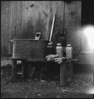 USA, Gruetli/TN: Farm; Diverse Gebrauchsgegenstände (Zuber, Einmachgläser, Besen...) auf und hinter einer Holzbank