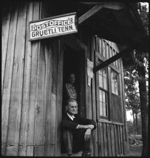 USA, Gruetli/TN: Menschen; Eine Frau und ein Mann in einer Holzhütte, an der das Schild "Postoffice Gruetli. Tenn." hängt