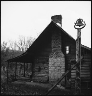 USA, Lincoln County/TN: Haus; Farmhaus mit grossem Kamin, daneben steht ein Stamm mit einer Glocke