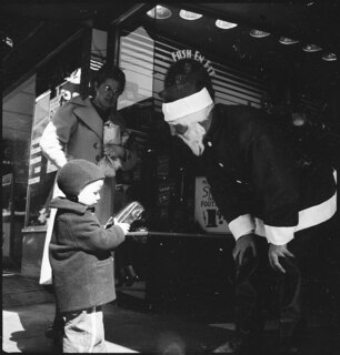 USA, Knoxville/TN: Menschen; Der Weihnachtsmann überreicht einem Kind ein Geschenk, daneben steht eine Frau