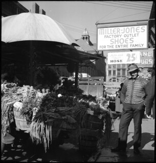 USA, Knoxville/TN: Markt; Ein Mann steht neben einem Marktstand mit Gemüse