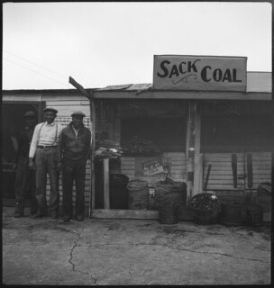 USA, Birmingham/AL: Häuser; Männer vor einer Hütte, daneben Kohlesäcke