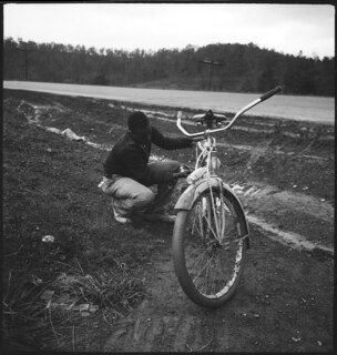 USA, Montgomery/AL: Menschen (Lokalisierung unsicher); Mann hantiert an einem Fahrrad neben einer Strasse