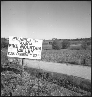 USA, Pine Mountain Valley/GA: Landschaft; Schild mit der Aufschrift "Premises of Georgia Pine Mountain Valley Rural  Community Corp." neben einer Strasse