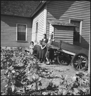 USA, Pine Mountain Valley/GA: Menschen; Zwei Frauen und ein Kind vor einem Haus, davor ein Gemüsefeld