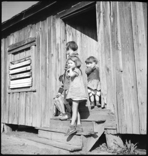 USA, Lumberton/NC: Menschen; Kinder auf Treppenstufen sitzend vor einer Holzhütte